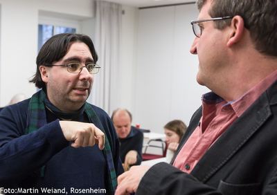 Zwei Turnierteilnehmer im angeregten Gespräch zwischen den Runden, einer unterstreicht seine Worte mit der Hand