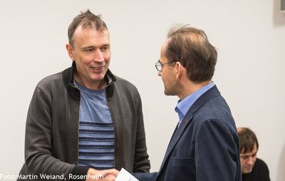 Händedruck bei der Siegerehrung: ein Teilnehmer erhält einen Umschlag mit seinem Preis
