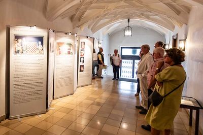Besucher vor den Roll-up-Tafeln der Ausstellung „Schach und Religion“ im gewölbten, hell gefliesten Gang des Ebersberger Rathauses