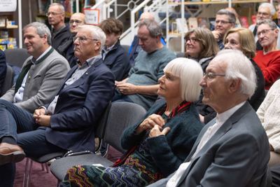 Aufmerksame Zuhörer in den ersten Reihen verfolgen die Eröffnung der Ausstellung