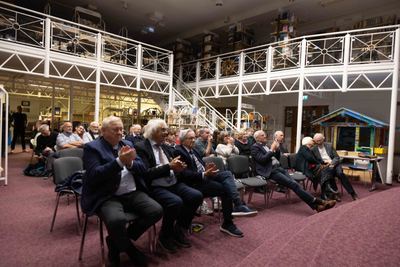 Applaudierendes Publikum in Stuhlreihen unter den weißen Galerien und Treppen der Stadtbücherei Grafing