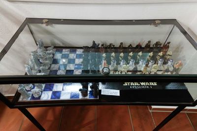 Vitrine mit zwei Sammlerschachspielen: Figuren aus Fantasy-Filmen auf blau-weißem Brett und Science-Fiction-Filmfiguren als Schachfiguren