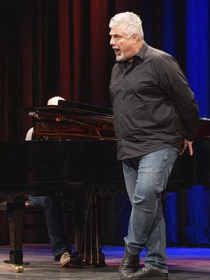 Sänger in schwarzem Hemd singt vor dem Flügel, an dem ein Pianist begleitet