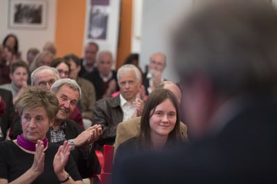 Applaudierendes Publikum in der Schachakademie, im Vordergrund unscharf der Hinterkopf eines Redners