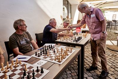 Händedruck über dem Schachbrett: Der Großmeister gratuliert einem Gegner bei der Simultanvorstellung